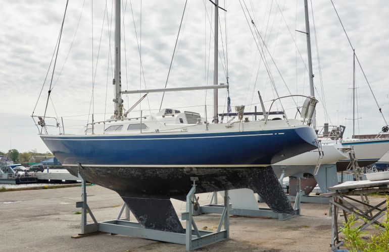 Zeilboot op een stalen bok op de kant in de haven