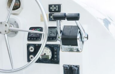 Stuurwiel en bedieningsconsole op een motorboot met diverse instrumenten