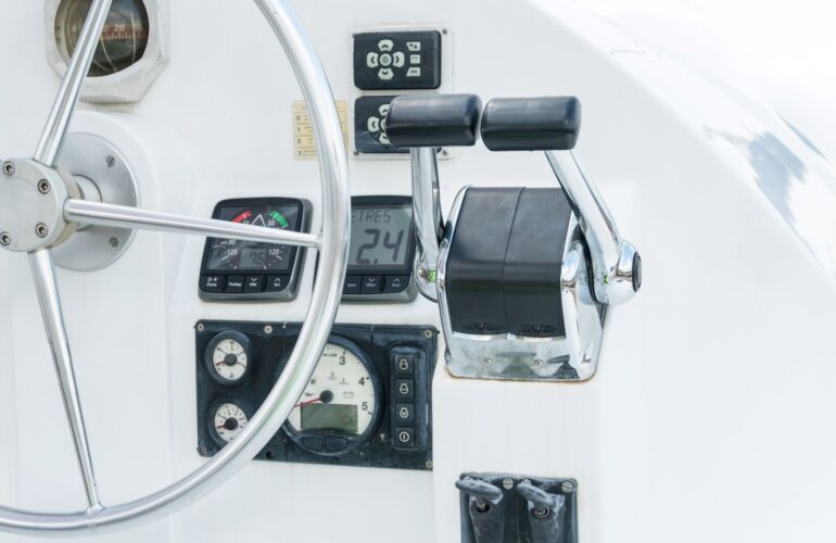 Stuurwiel en bedieningsconsole op een motorboot met diverse instrumenten