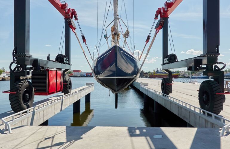 Zeilboot in botenlift boven het water in jachthaven